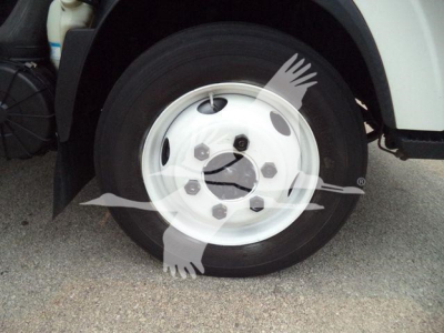 Isuzu NPR HD front wheel and tire showing hubcap and part of fender; side view with wheel and part of truck body