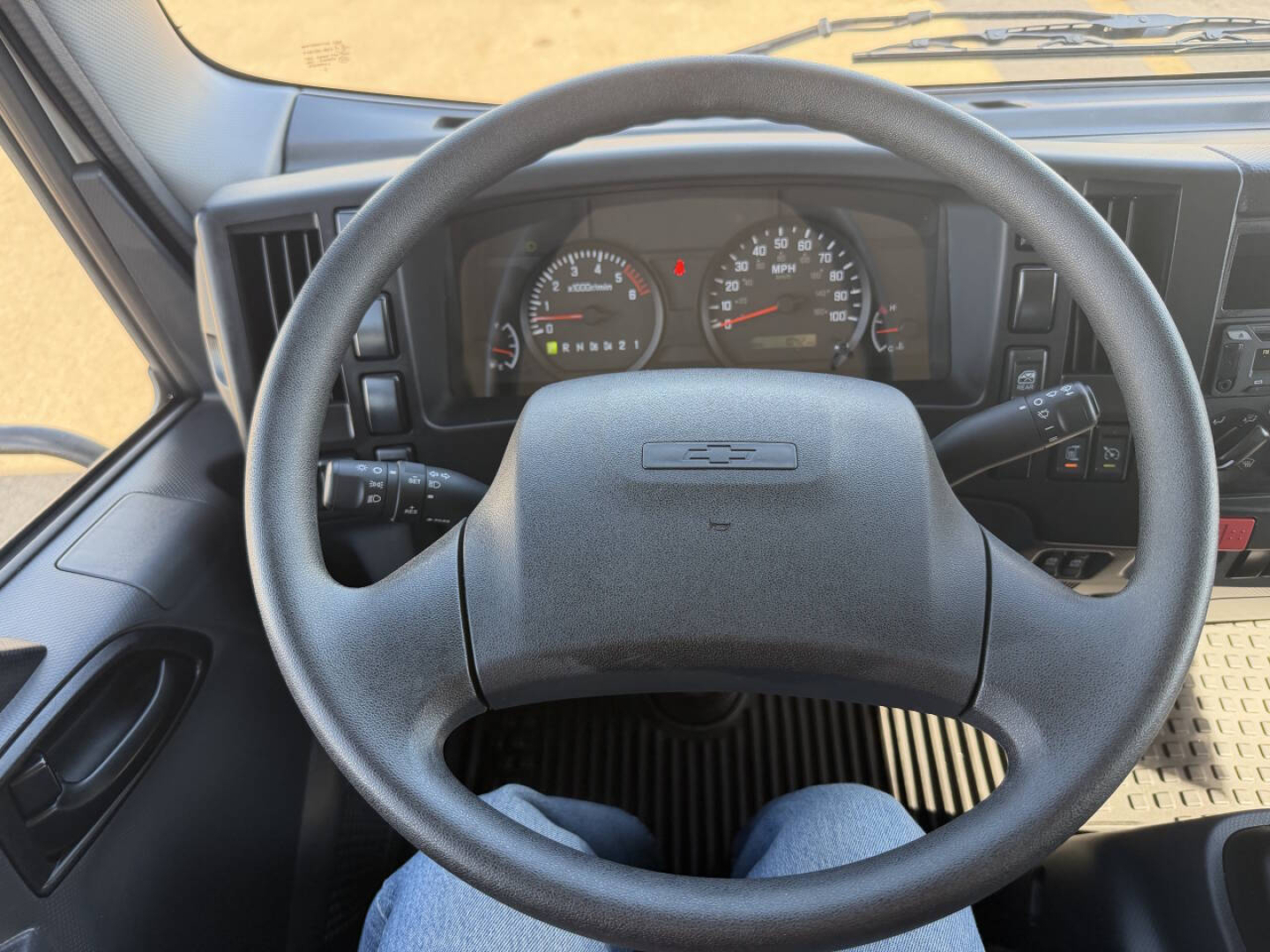 Truck interior dashboard view from driver seat of 2024 Chevrolet 4500 LFC showing steering wheel, instrument cluster, and front controls.