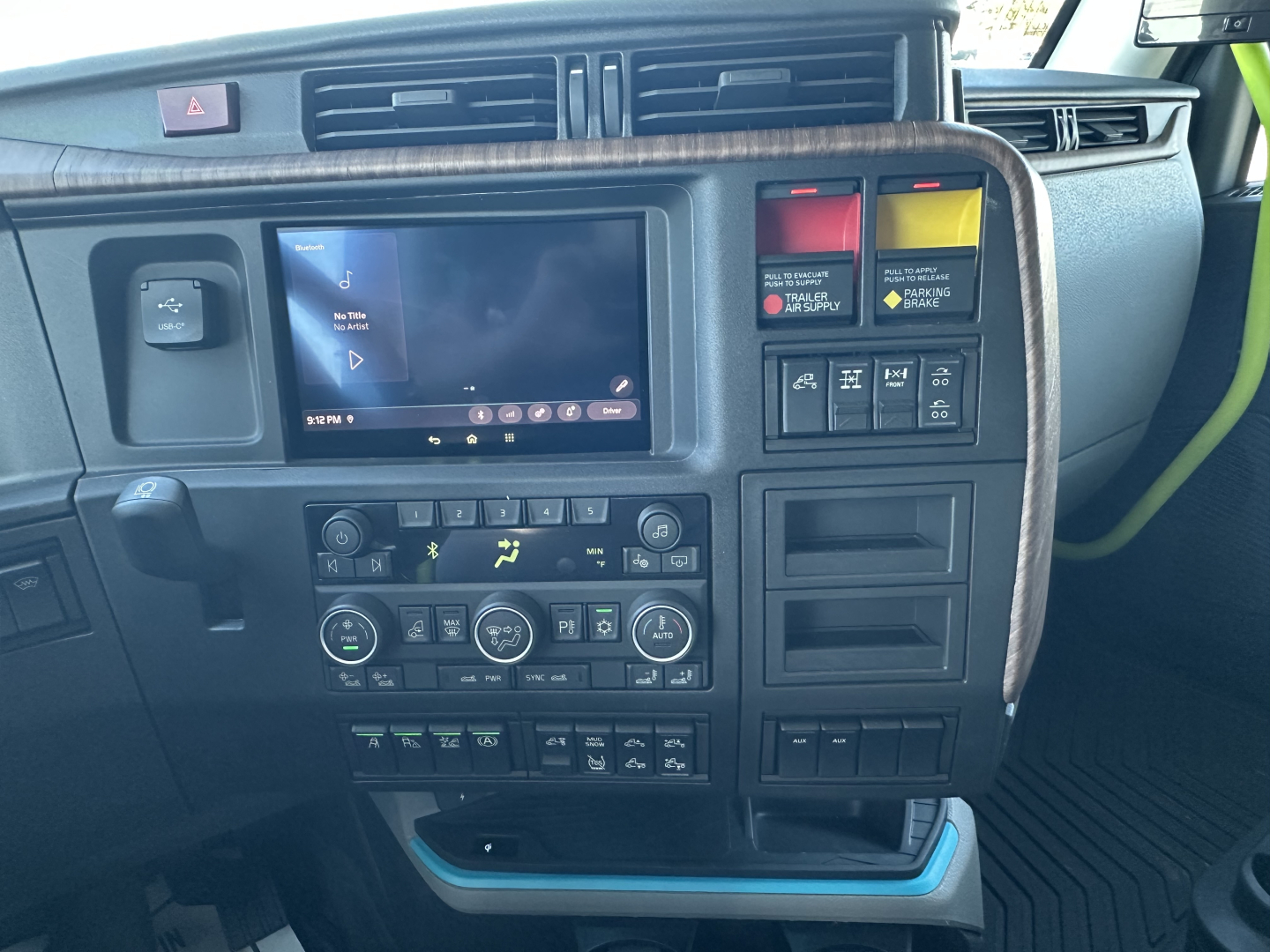 Dashboard and center console of a Volvo VNL64T860 truck showing touchscreen display, climate controls, and switch panels.