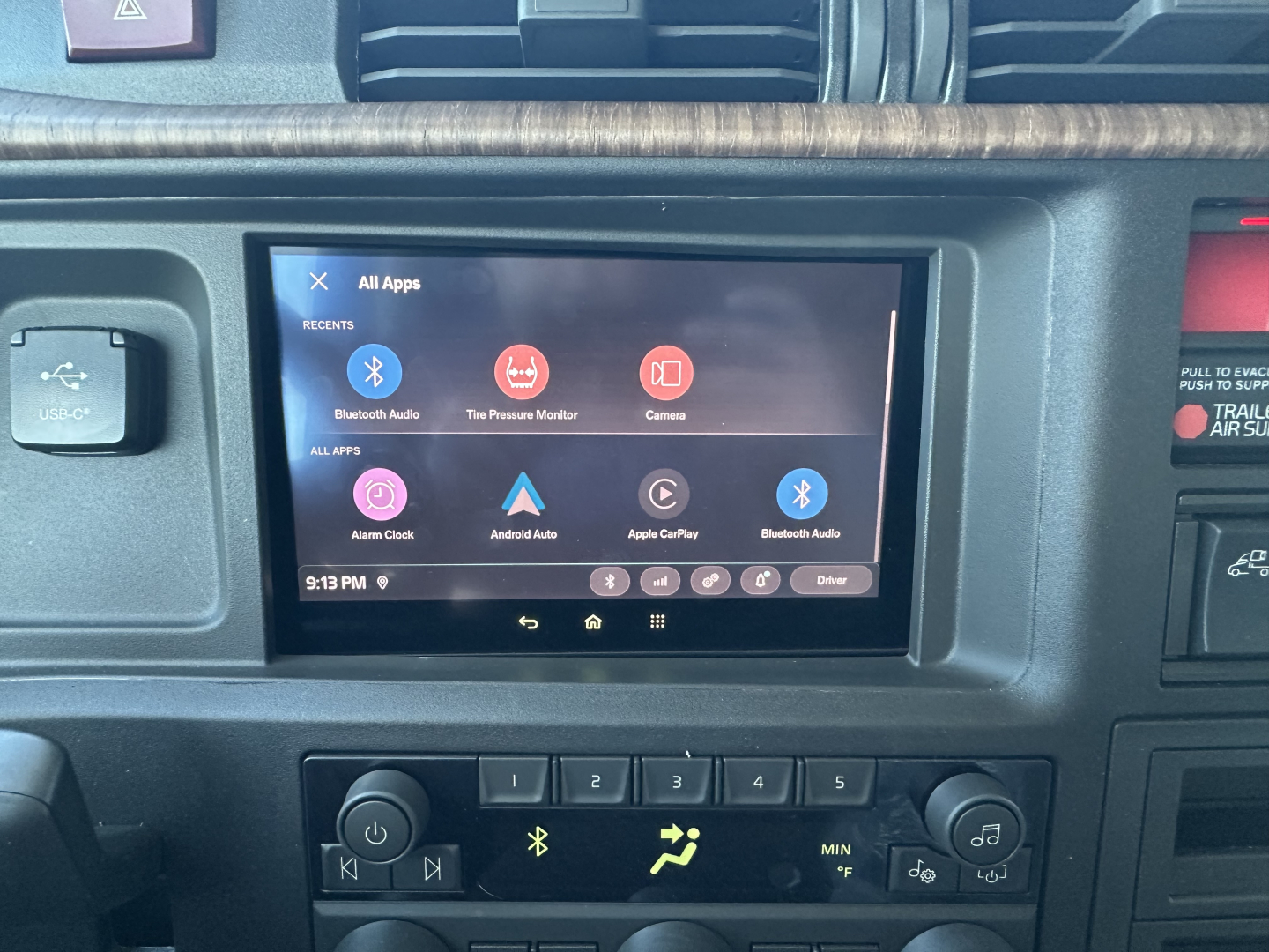 Dashboard view of a 2026 Volvo VNL64T860 truck showing a tablet-style infotainment screen with Bluetooth, apps icons, and climate controls visible below.