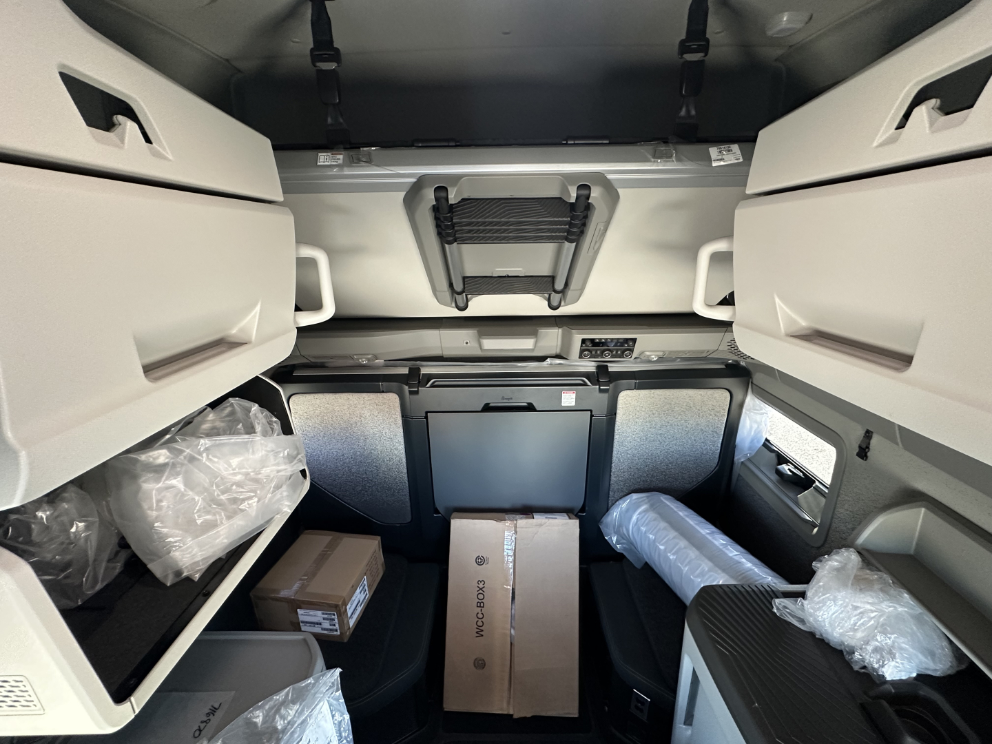 Volvo VNL64T860 sleeper cab interior showing storage compartments and packaged items.