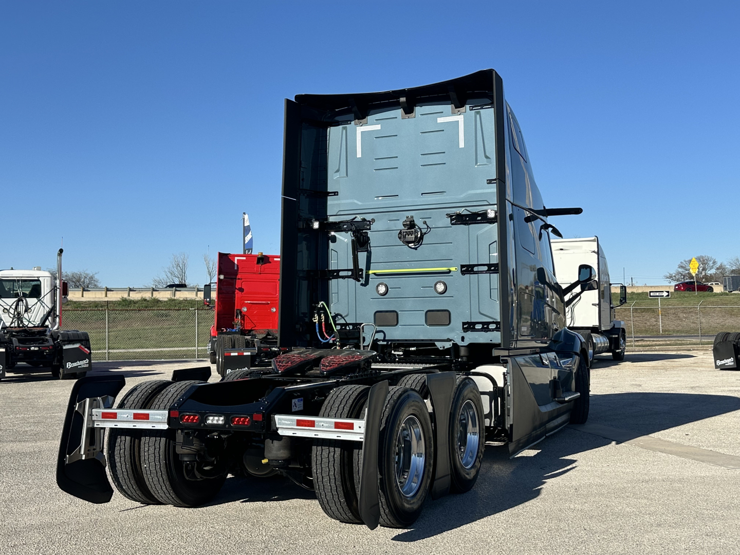Volvo VNL64T860 cab and rear view showing tractor fifth wheel area and rear tires in a showroom lot.