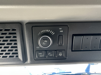 Volvo VNL cab interior control panel showing circular dial and five switches.
