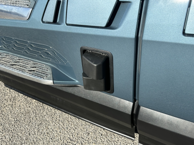 Volvo VNL64T860 truck door area showing a compact black rectangular step/step well and side panel with textured grille