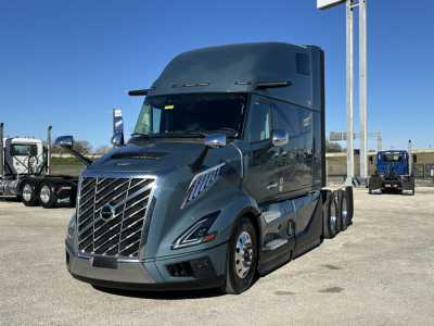 2026 Volvo VNL64T860 front-left view in a dealership lot with chrome grille, large sleeper cab, and blue-gray paint.