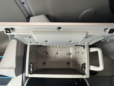 Volvo VNL64T860 sleeper cab interior showing open center storage drawer with inner compartments and metal mounting rails.