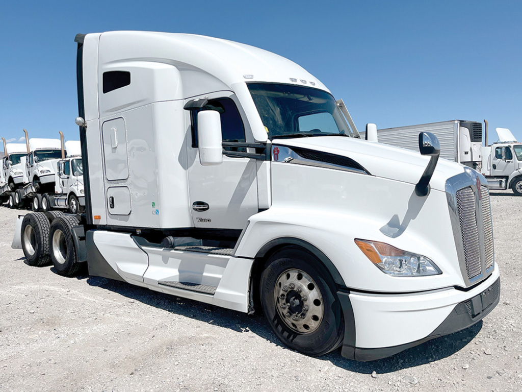 Kenworth T680 Next Gen conventional sleeper truck in white, side view, with large aerodynamic cab and dual rear axles, front grille and headlights visible.