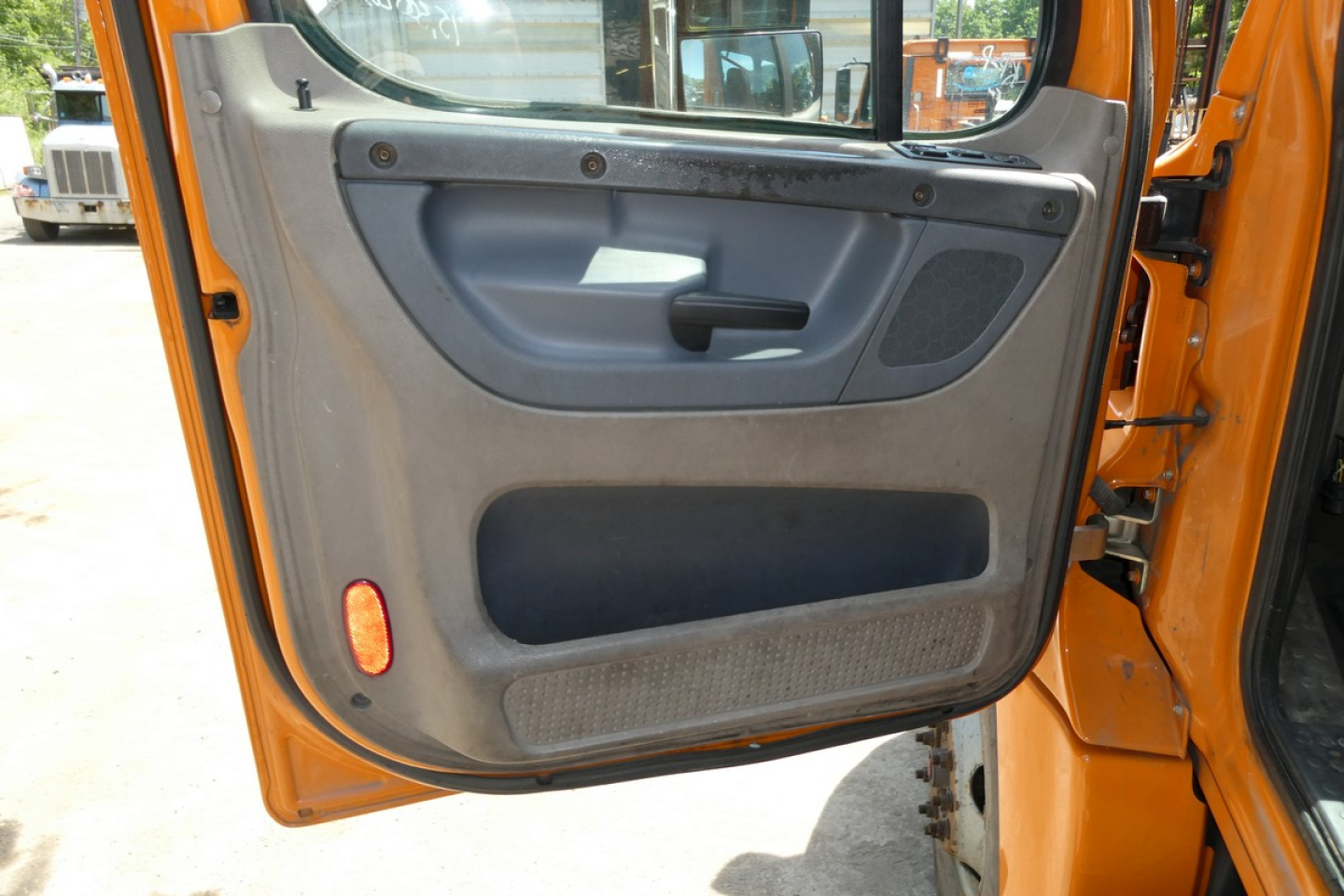 Truck cab interior door panel view showing manual window switch and storage pocket.