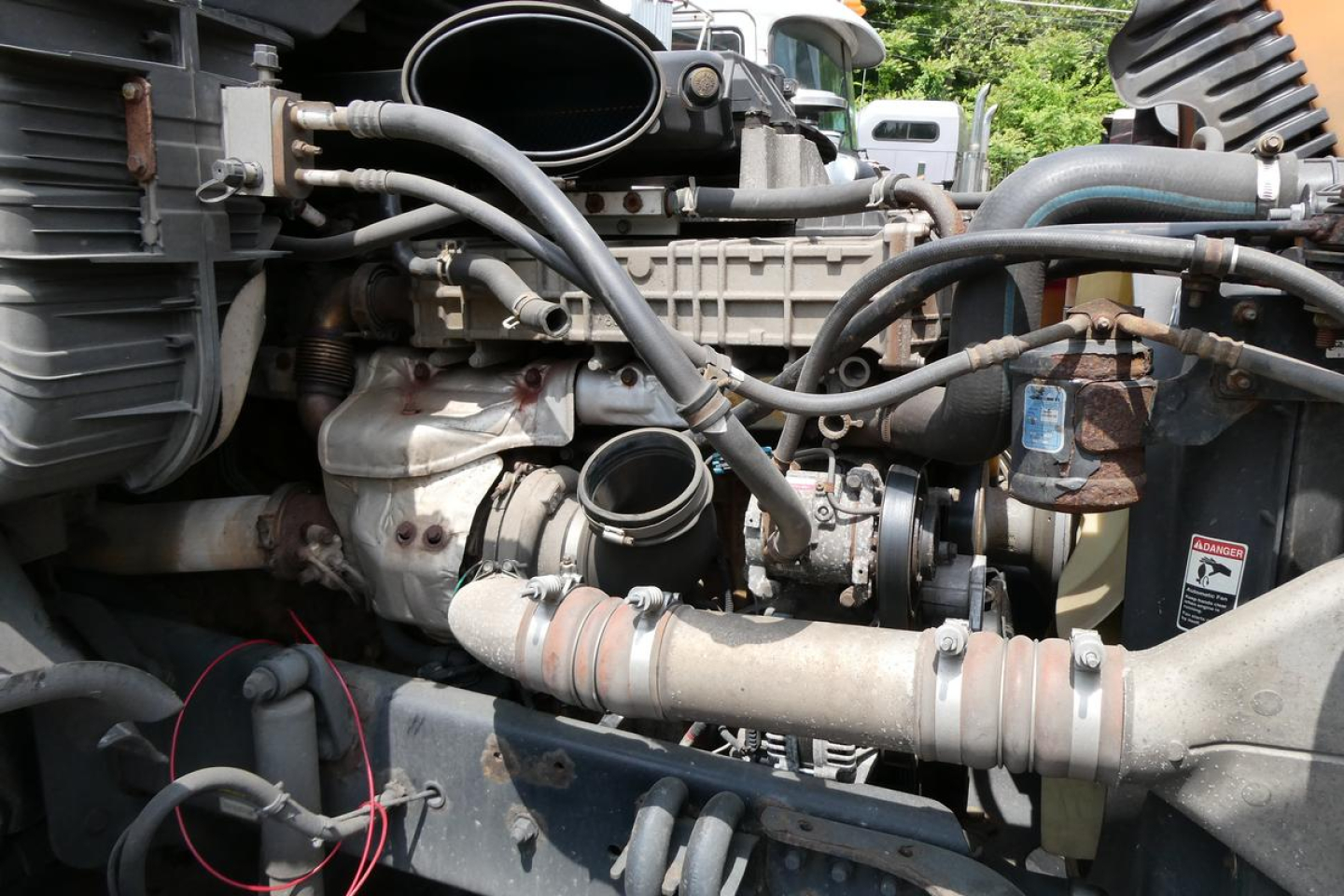 Freightliner Cascadia 125 engine bay showing intake hoses, turbocharger, and intercooler piping with various clamps and a circled area highlighting a component.