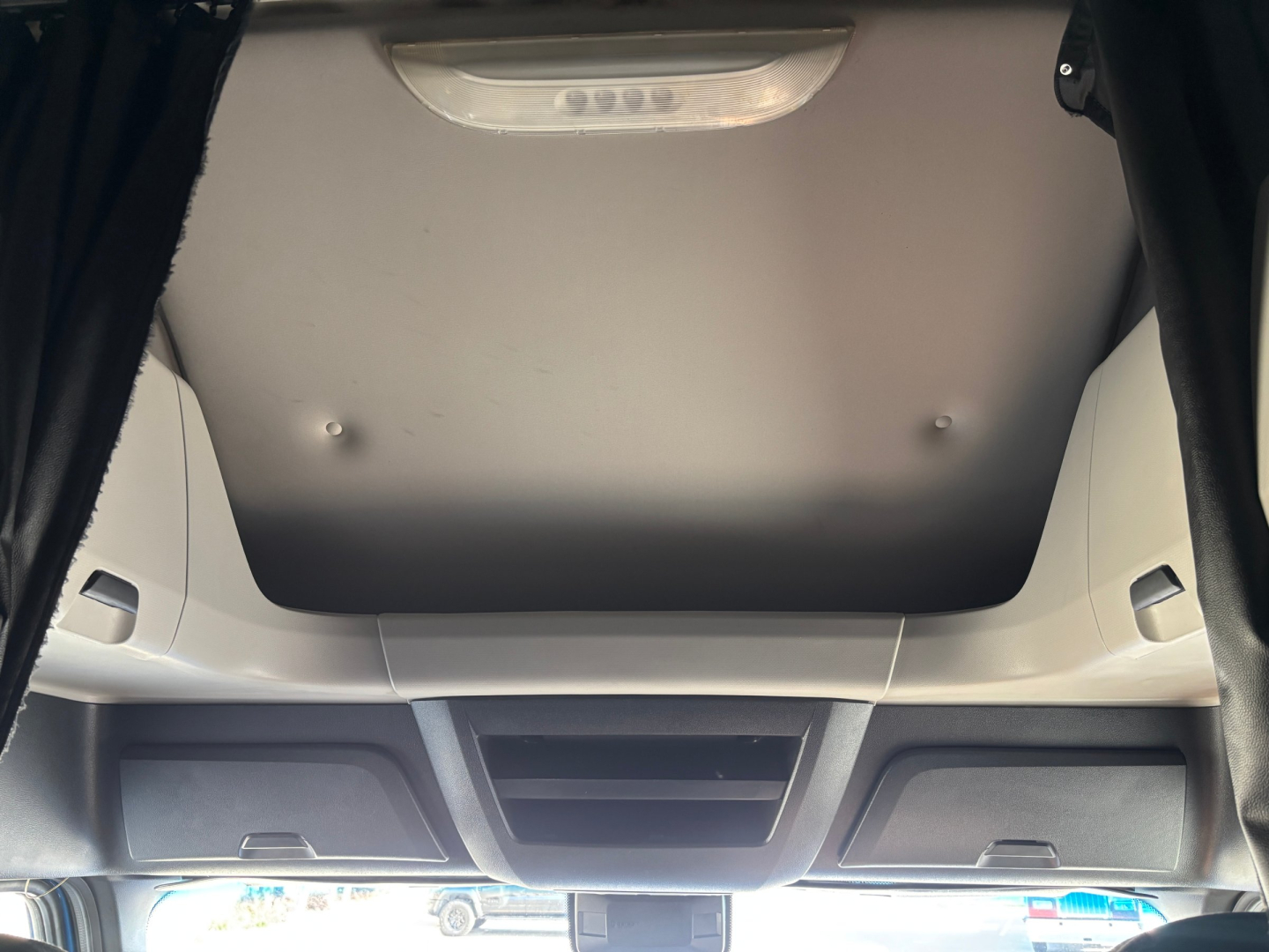 Cab interior of a Freightliner truck, overhead console and ceiling with storage compartments visible.