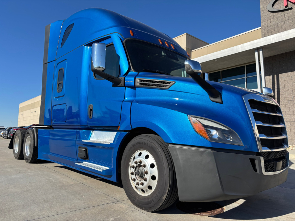 Freightliner PT126064ST truck cab in blue with highlighted side view showing front grille, side mirror, and aerodynamic design.
