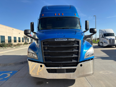 Freightliner highway tractor with blue cab, black grille, and chrome bumper. Front view showing no text clearly on the grille area; no legible labels visible.