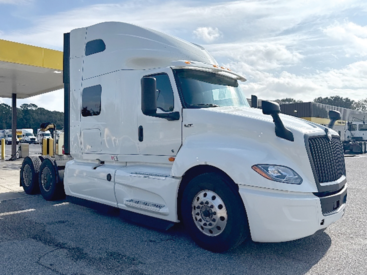 International LT Series truck cab showing large sleeper with white paint, dual rear axles, and prominent grille; front left view.