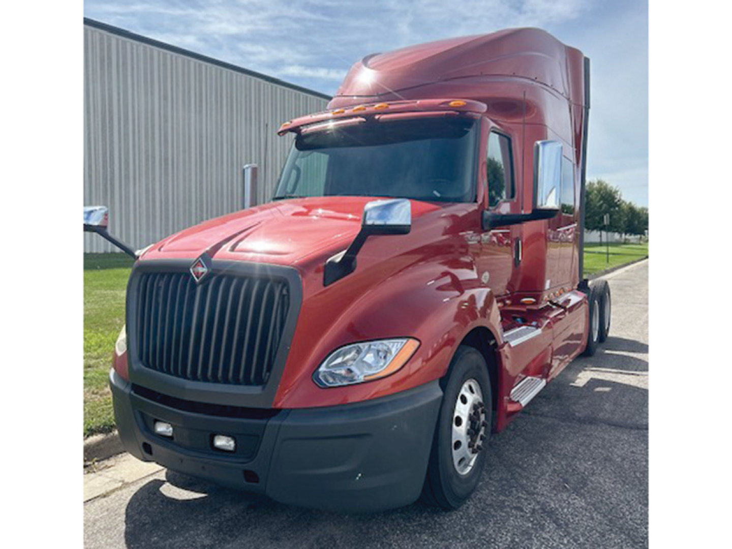 Red 2020 International LT625 tractor truck cab front-left view with large black grille and integrated sleeper, side mirrors, and aerodynamic hood.