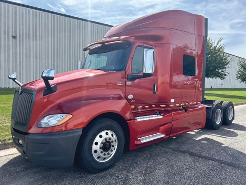 Truck cab and sleeper unit of a red 2020 International LT625 tractor-trailer viewed from the front-left side.