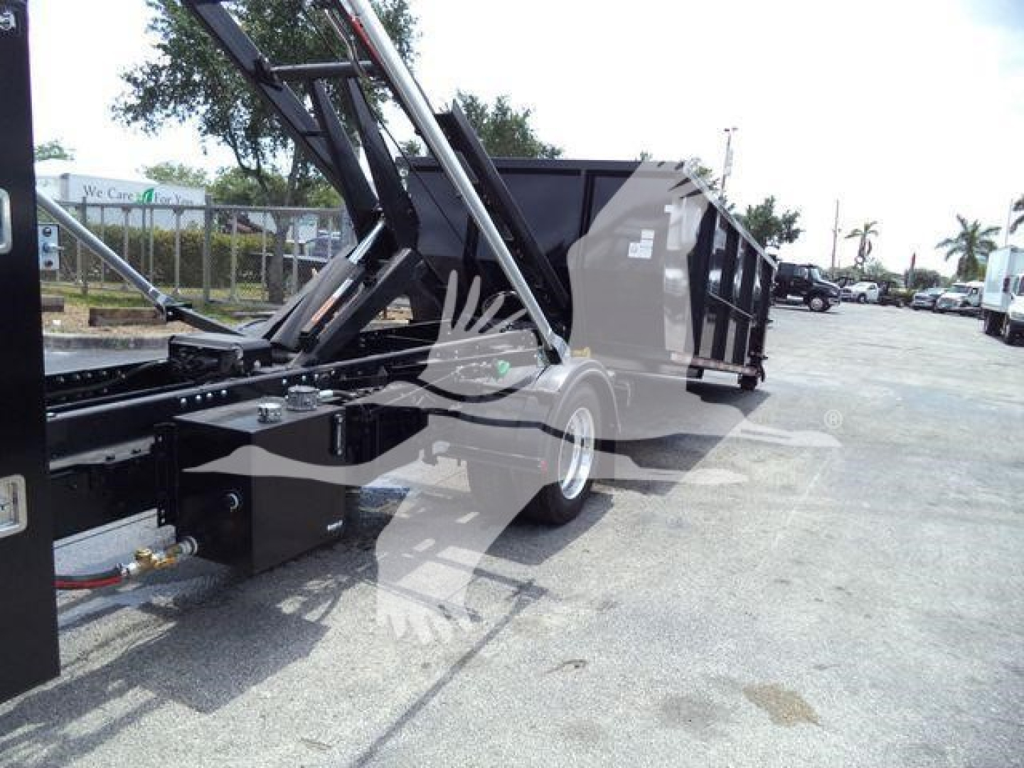 Truck chassis of a 2023 Chevrolet Silverado 6500HD with a dump bed and hydraulic lift, showing front frame and wheels.