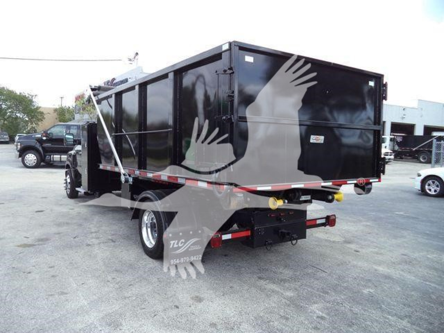 Truck bed with black dump body mounted on a Silverado chassis, rear view showing tail lights and hitch, stock number 6500SNGTRUCK3.