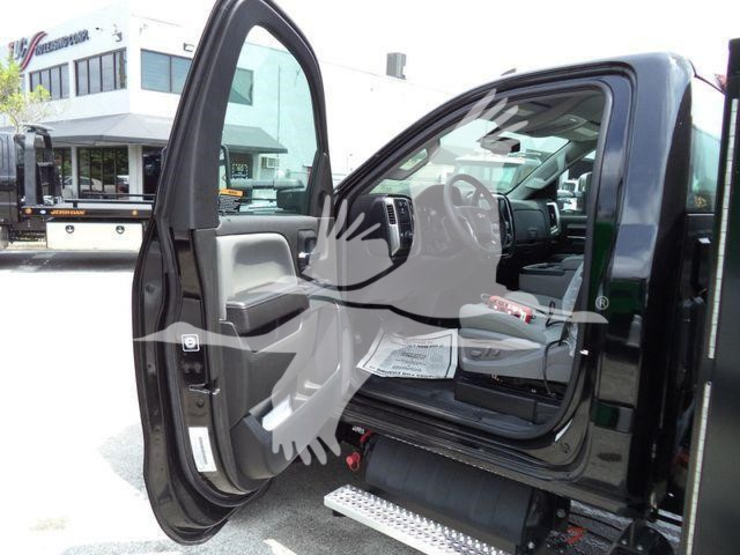 Truck cab interior with open driver door showing Chevrolet Silverado 6500HD interior and steps