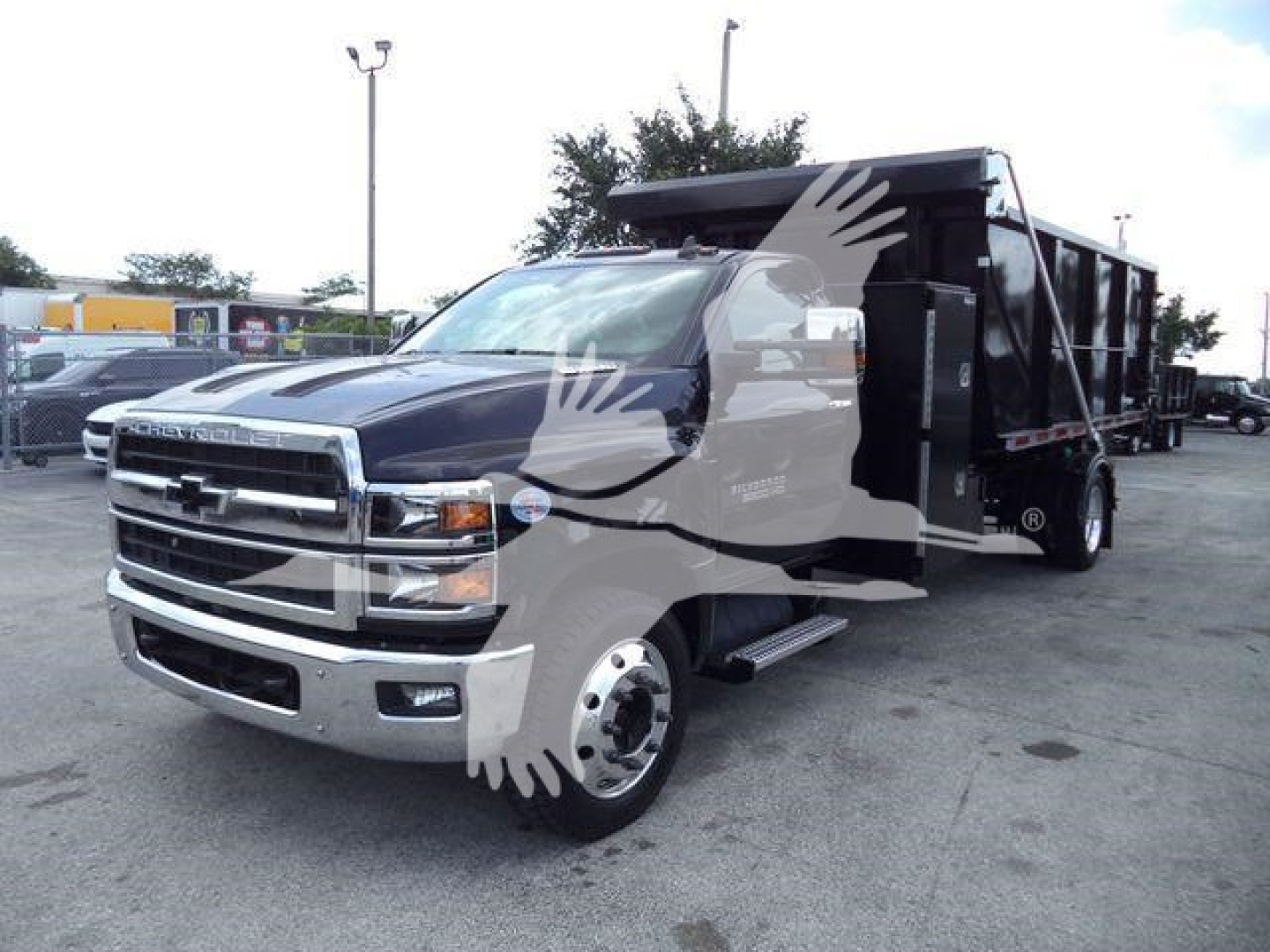 Chevrolet Silverado 6500HD dump truck side view showing front grille with Chevy emblem and heavy-duty dump bed.