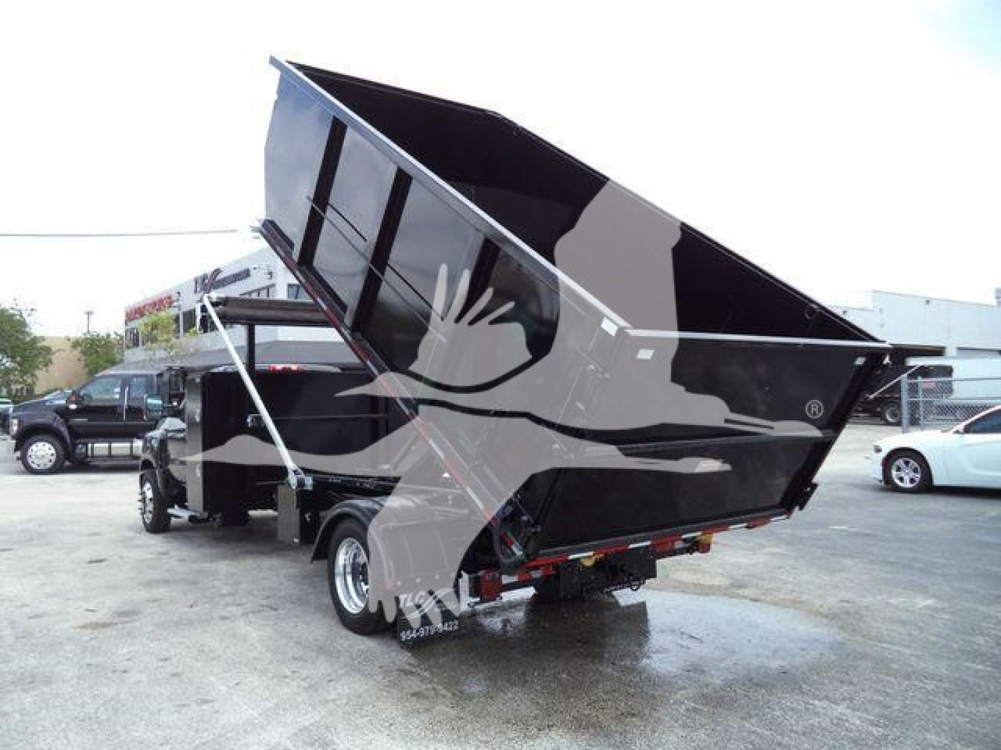 Chevrolet Silverado 6500HD dump truck in raised bed view showing hydraulic lift and rear dump mechanism.