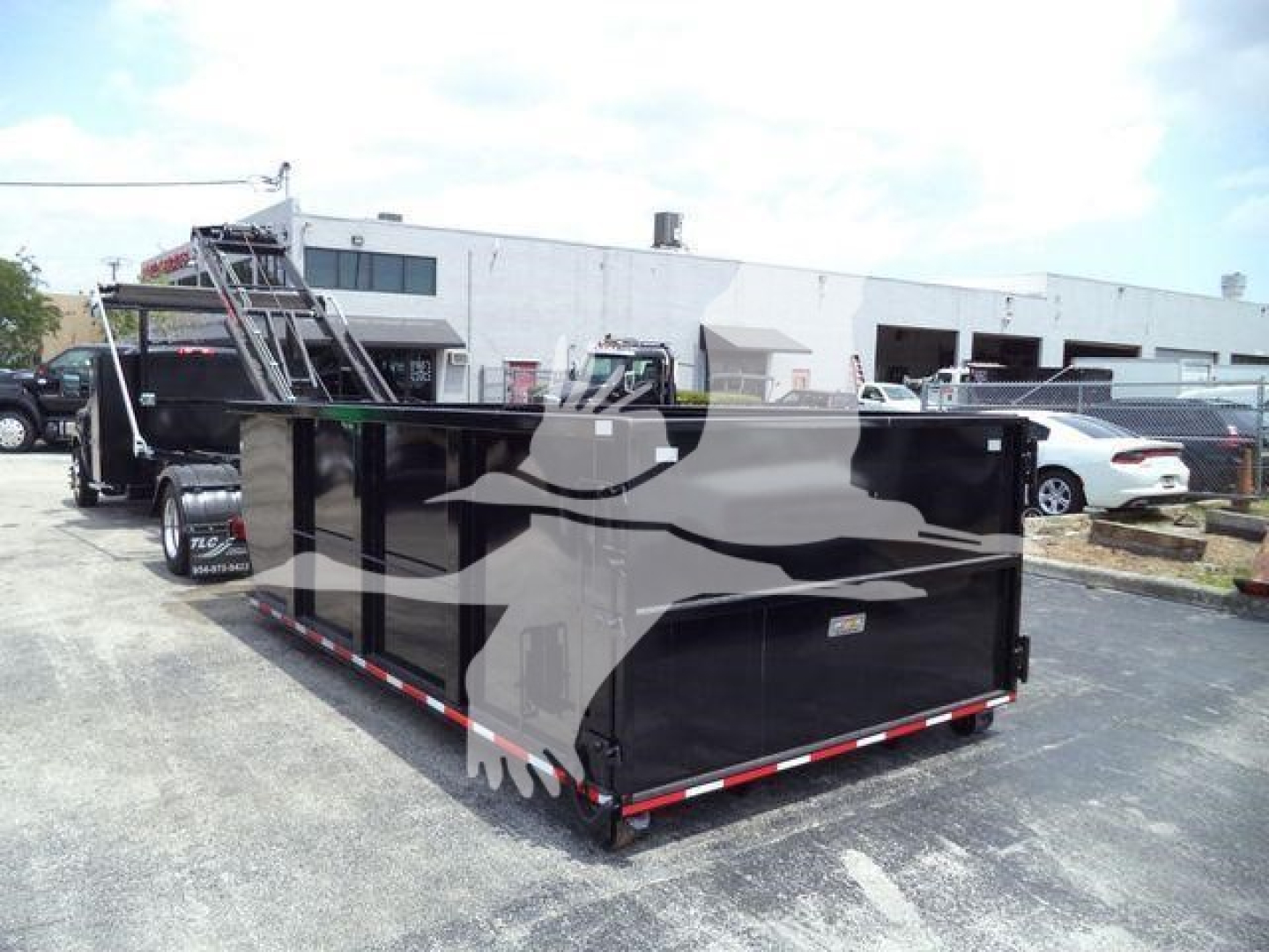 Trailer bed with black sidewalls and reflective red-and-white trim in a dealership lot