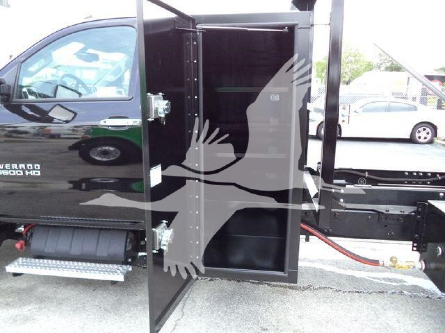Chevrolet Silverado 6500HD truck cab and rear cargo area with open side door and steps visible.