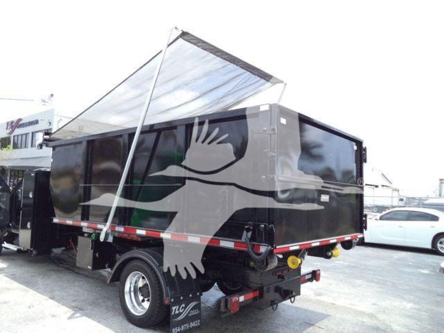 Dump trailer with open-top black hopper showing side and rear view, white push bar, and reflective tape along sides.