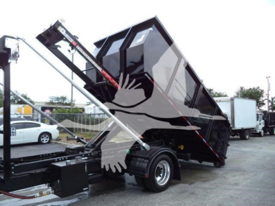 Truck bed dump mechanism of a 2023 Chevrolet Silverado 6500HD with raised dump body and hydraulic cylinders.