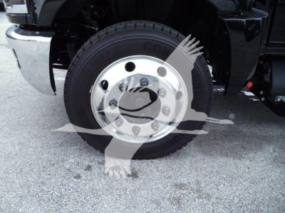 Front wheel of a Chevrolet Silverado 6500HD truck showing a Goodyear or similar tire mounted on a polished steel wheel; no legible model text visible on tire.