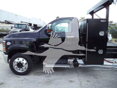 Chevrolet Silverado 6500HD cab with utility bed and crane mounting in a dealership lot; black exterior with chrome front hub, side step, and reinforced service body