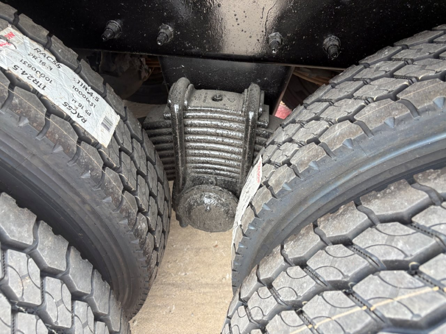 Rear view showing tandem axle differential and dual rear tires on Mack GR64F dump truck.