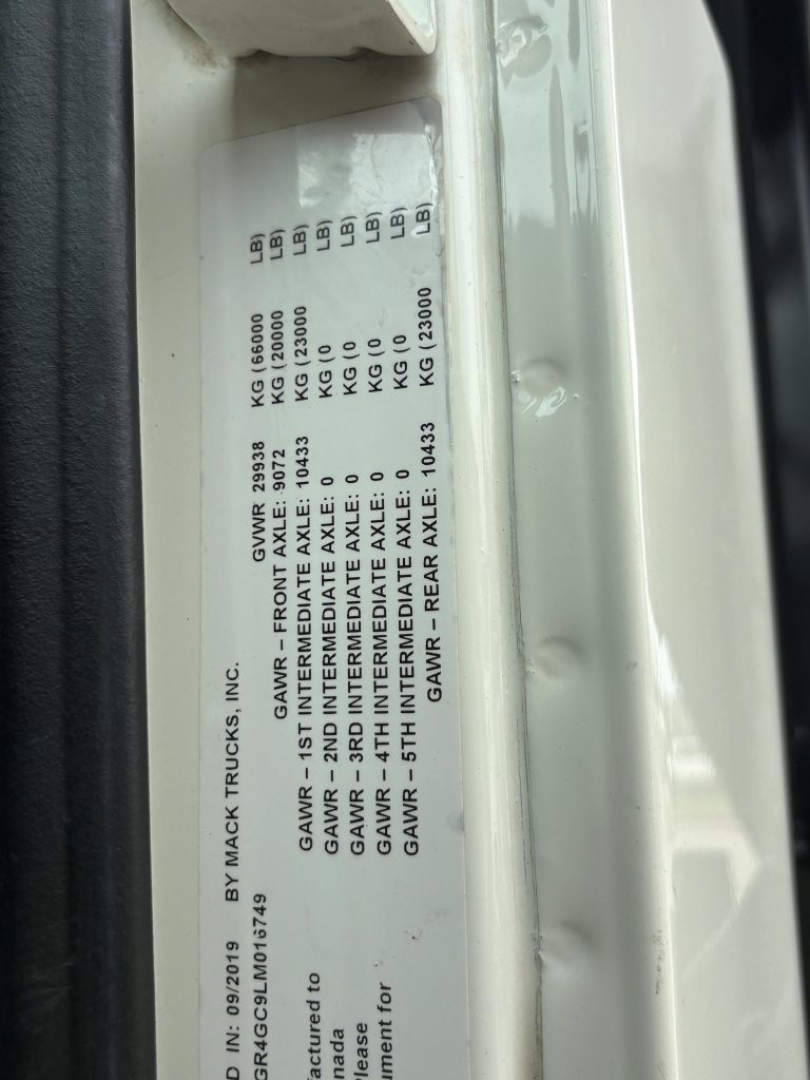 VIN plate on Mack GR64F showing GVWR and GAWR weights and axle specs in a vertical orientation.