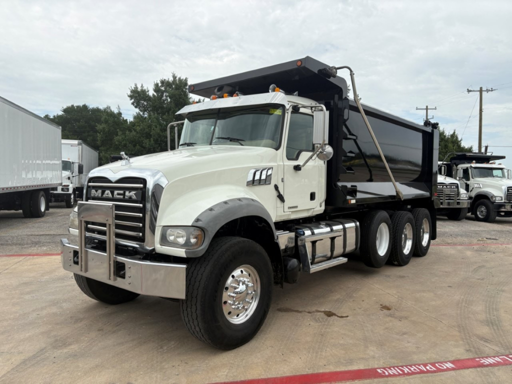 Mack GR64F dump truck in-service showing front grille and dump bed with chrome bumper and five-wheel configuration.