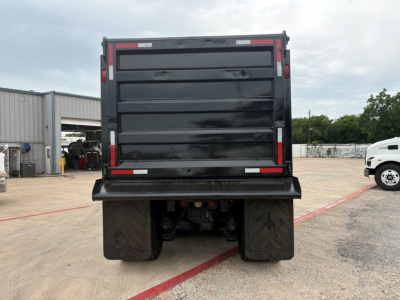 Rear view of a 2020 Mack GR64F dump truck showing back of cargo bed and dual rear tires.