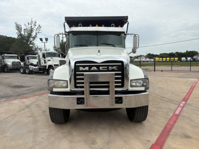Front view of a white 2020 Mack GR64F dump truck showing chrome grille with MACK lettering, bumper guard, large headlights, and elevated cab.