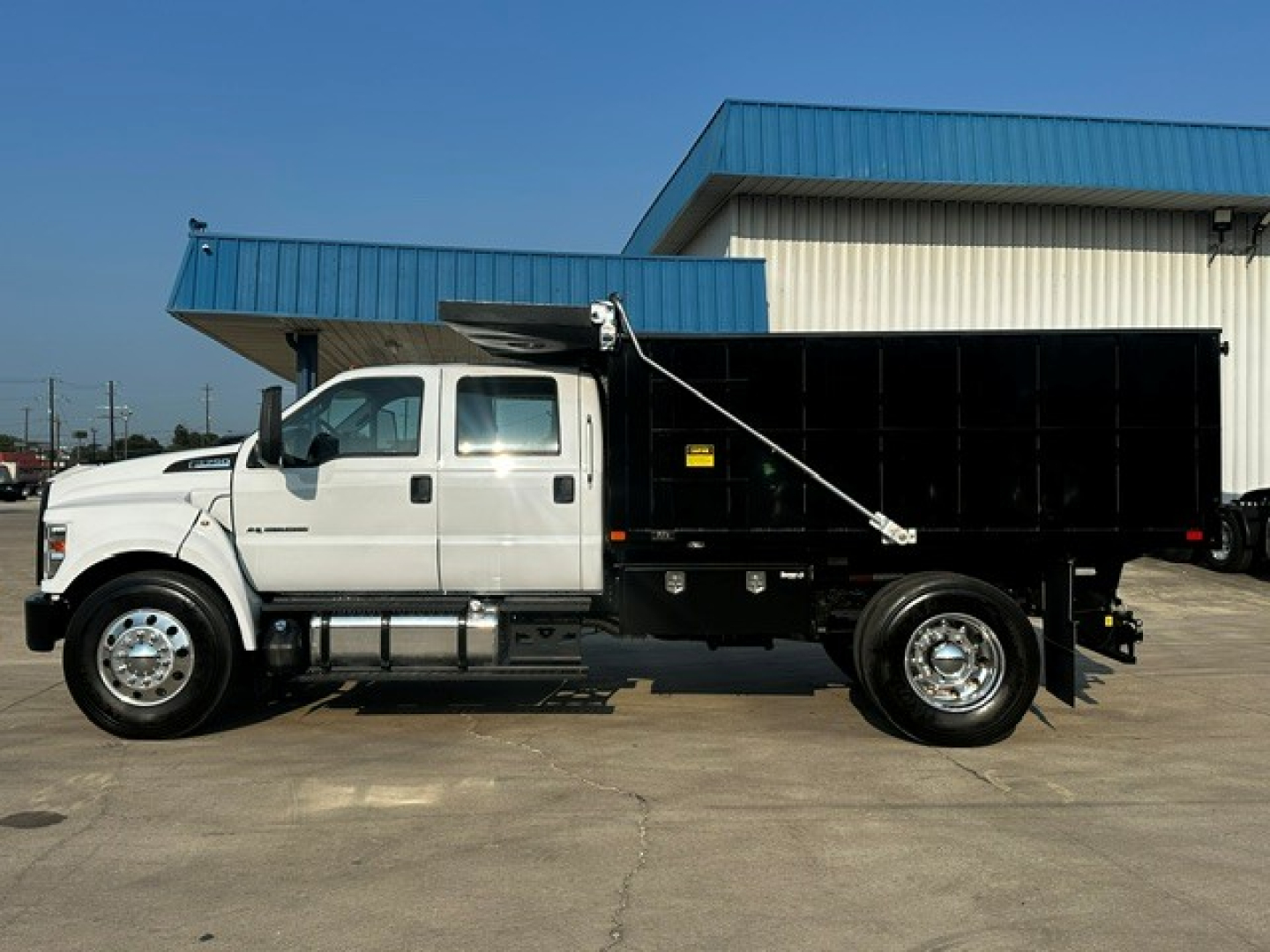 Ford F750 dump truck side view showing cab and black dump bed