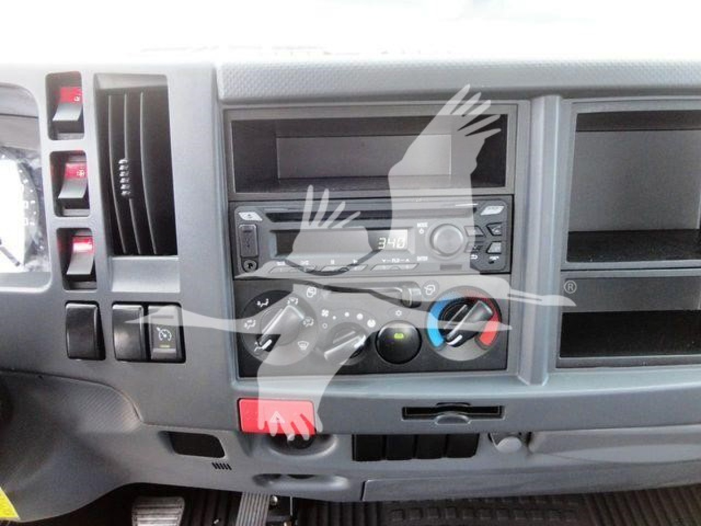 Isuzu NPRR dashboard showing controls and climate knobs with radio slot and empty compartments.