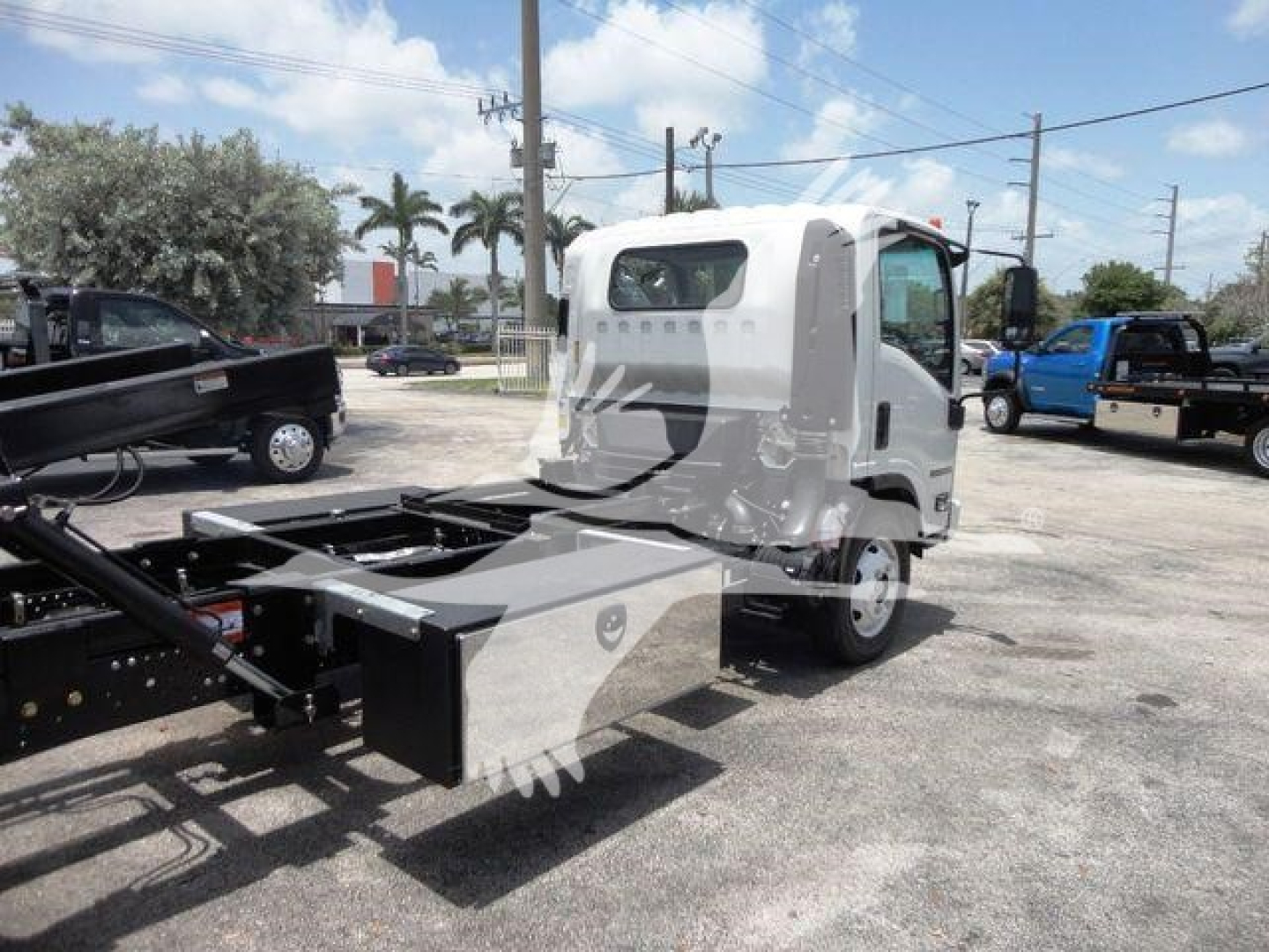 Isuzu NRR rollback truck chassis with cab in view showing cab, chassis frame, and rear hitch area.