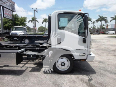 Isuzu NPR truck cab side view showing steering wheel and door, with rollback chassis and wheel visible.
