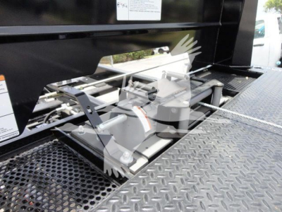 Isuzu NPRR truck rollback setup showing front winch and hydraulic mounting system with metal platform and diamond plate surface.