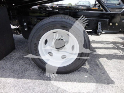 Wheel and undercarriage of 2024 Isuzu NPRR rollback truck showing Goodyear tire and white steel wheel.