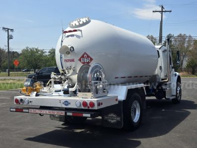 Freightliner M2 tank truck rear view showing propane tank, rear bumper with taillights and warning placards, and Westmor mud flaps.