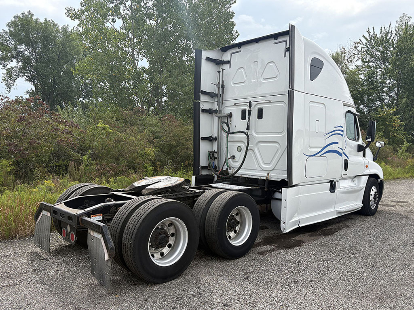 Freightliner Cascadia125 tractor cab with rear view showing dual rear axles and fifth wheel plate.