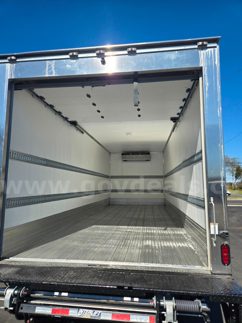 Isuzu NPR box truck cargo area with open rear doors showing empty white walls, cargo rails, and metal floor.