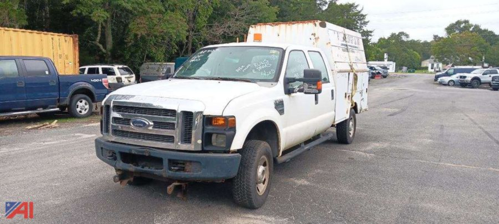 Ford F-350 Super Duty utility work truck with white cab and utility bed, front grille, bumper, and large side mirrors.