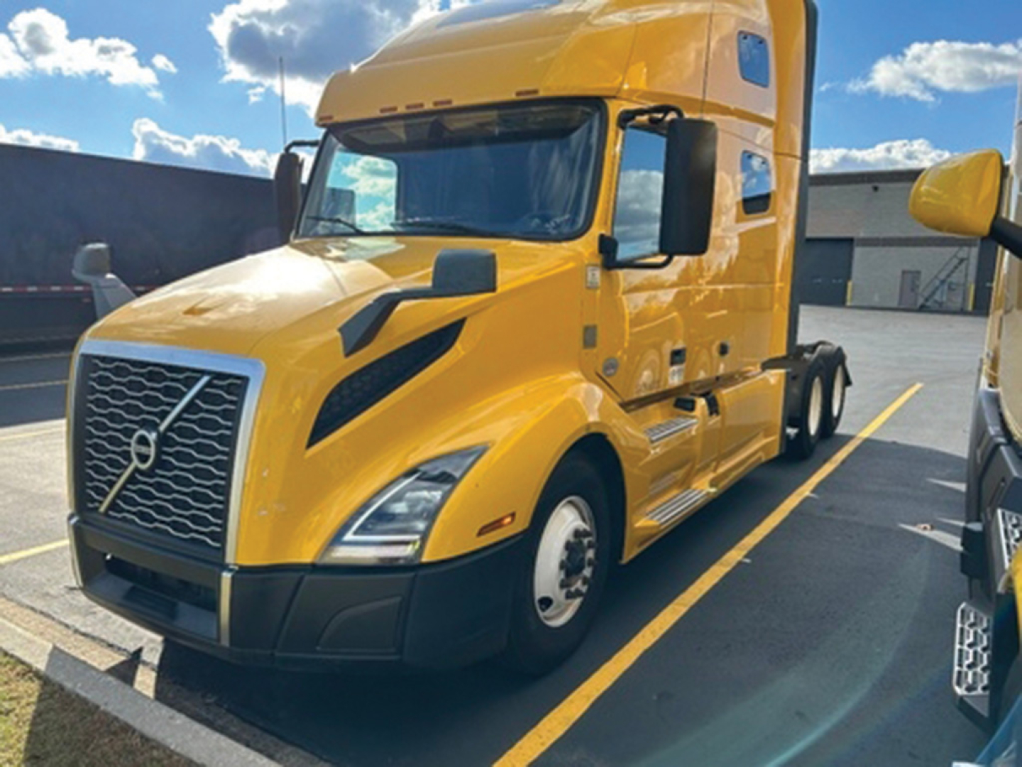Volvo VNL 760 sleeper tractor in yellow front-left view showing grille, headlights, and cab details.
