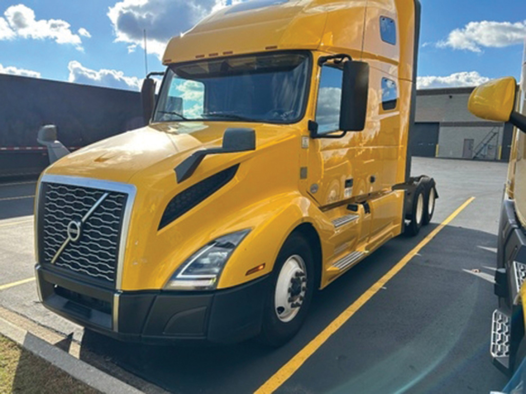 Volvo VNL 760 sleeper tractor in yellow front-left view showing grille, headlights, and cab details.
