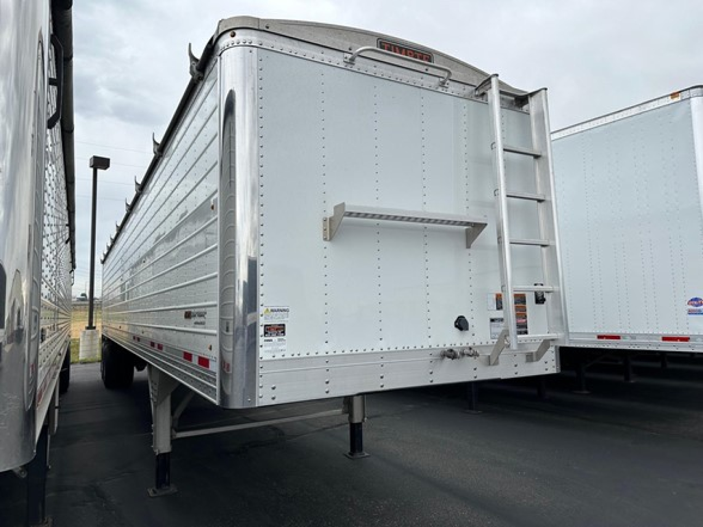 Timpte Super Hopper trailer showing rear view with landing gear deployed and rear doorway closed.