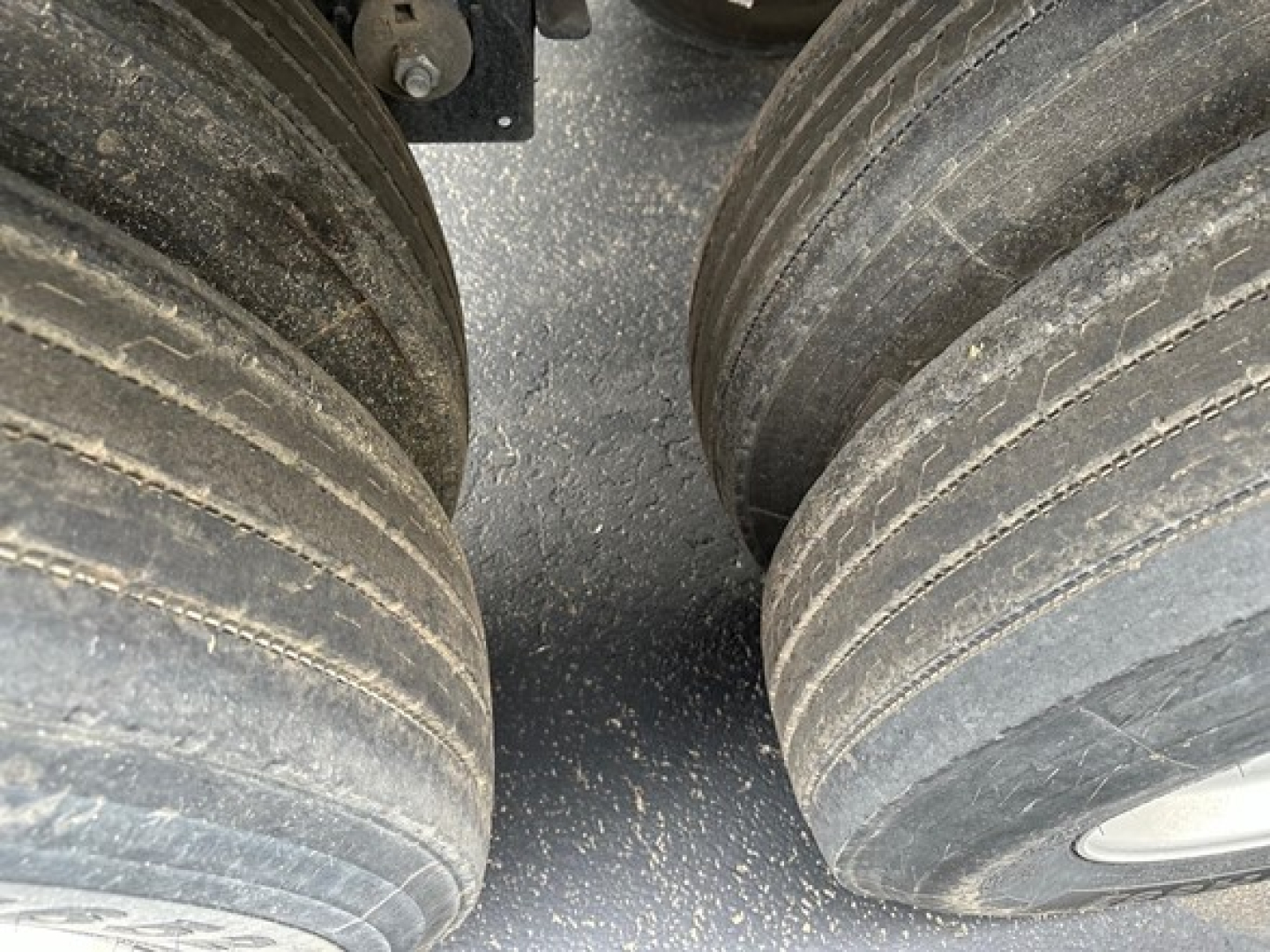 Trailer wheel area showing dual heavy tires with visible tread and dirt; part of a Timpte hopper trailer.