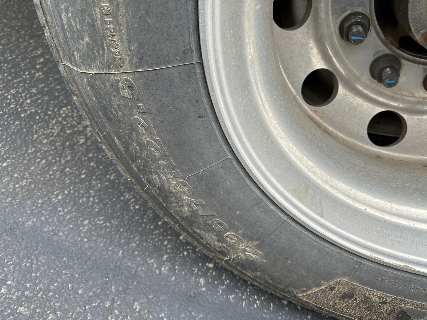Timpte Super Hopper trailer wheel and tire close-up with metal rim and lug nuts visible.